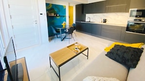 Una cocina moderna con microondas, horno y comedor con mesa y sillas.