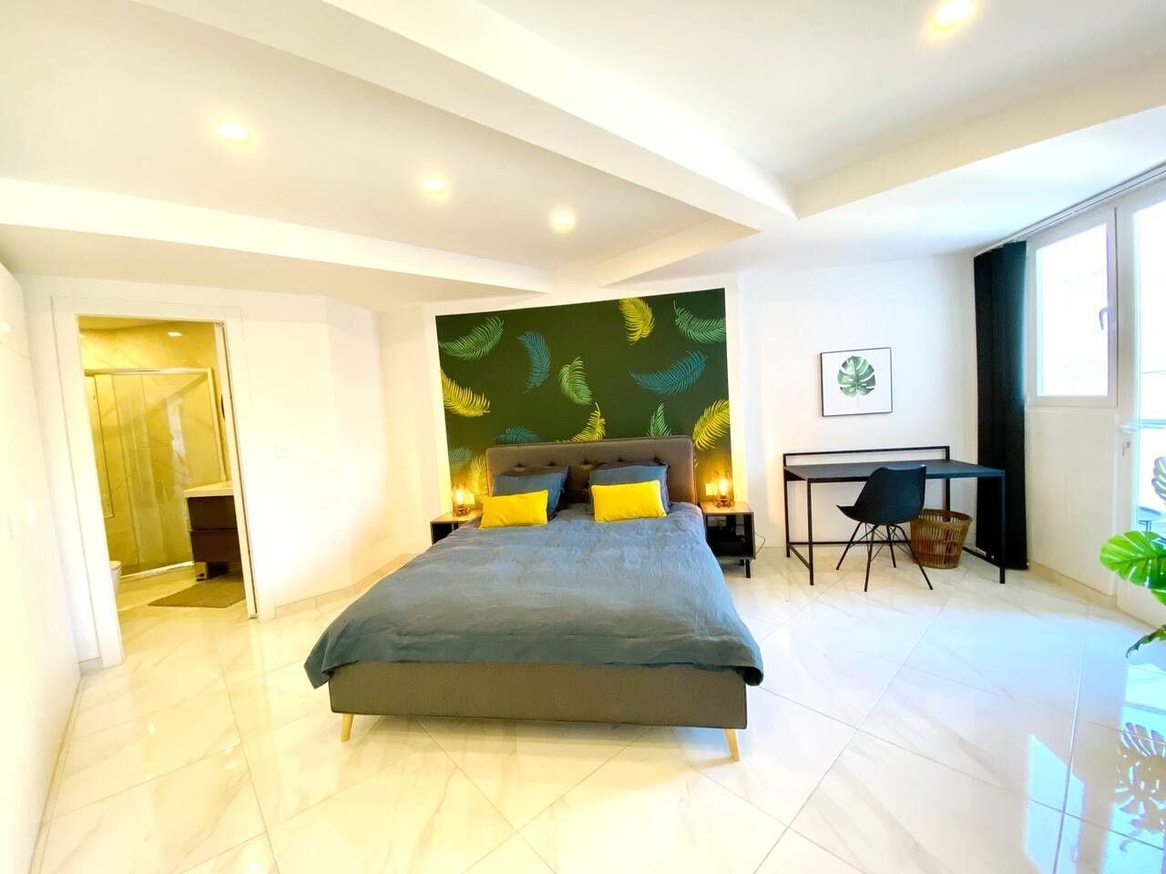 Une chambre moderne avec un grand lit, des tables de chevet, un bureau et une chaise.