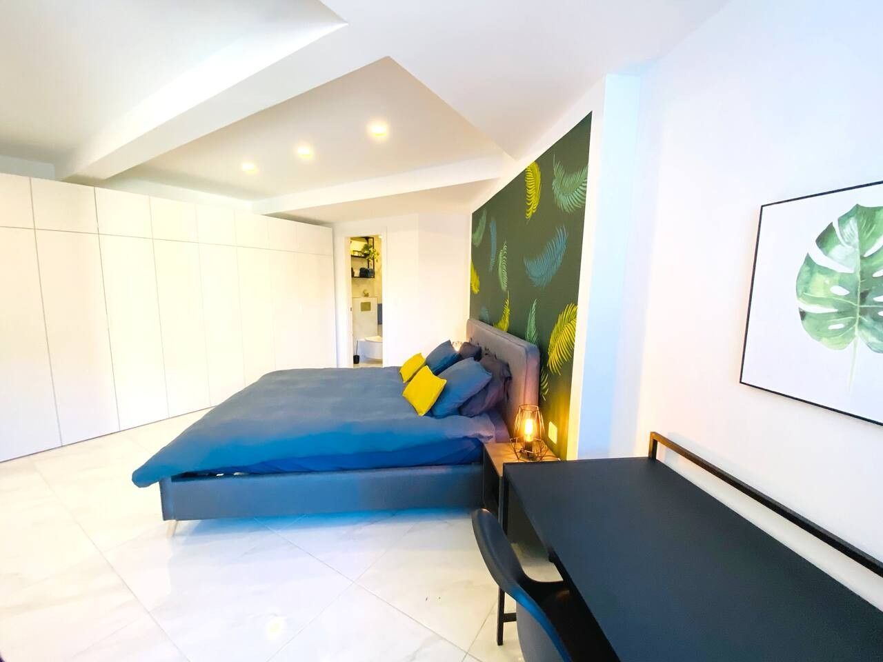 Ein modernes Schlafzimmer mit einem Bett, einem Nachttisch und einem Wandbild.