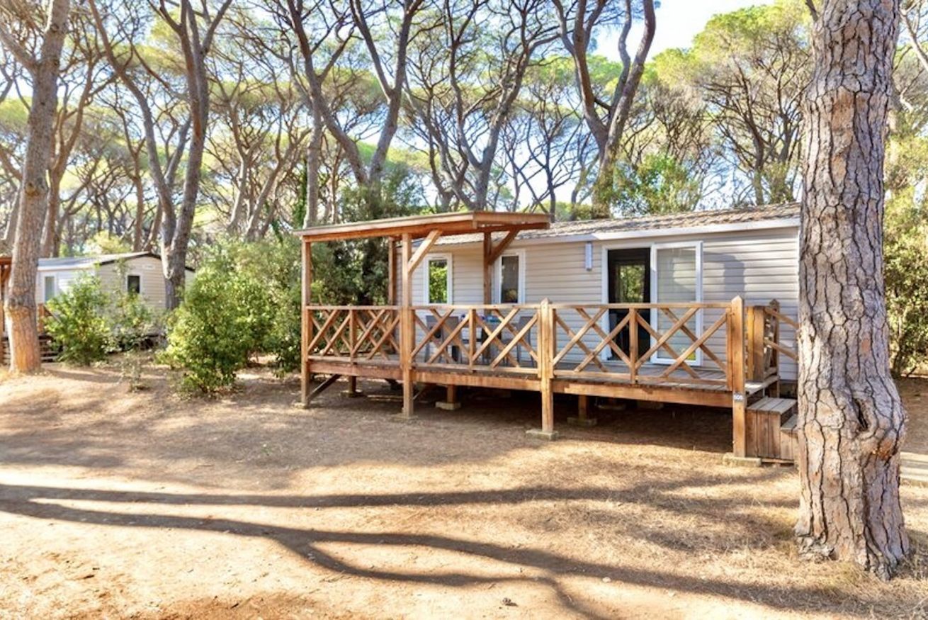 A mobile home with a wooden deck and a covered porch.