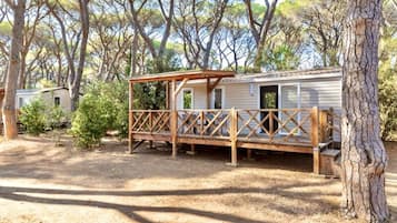 A mobile home with a wooden deck and a covered porch.