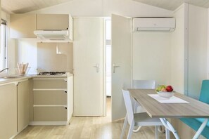 A compact kitchen with a gas stove, a built-in oven, and a white cabinet.