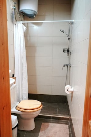 A small bathroom with a toilet, a shower, and a towel rack. - Valletta Retreat apartment (Valletta)