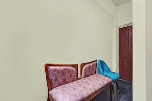 A hallway with a wooden bench and a door.