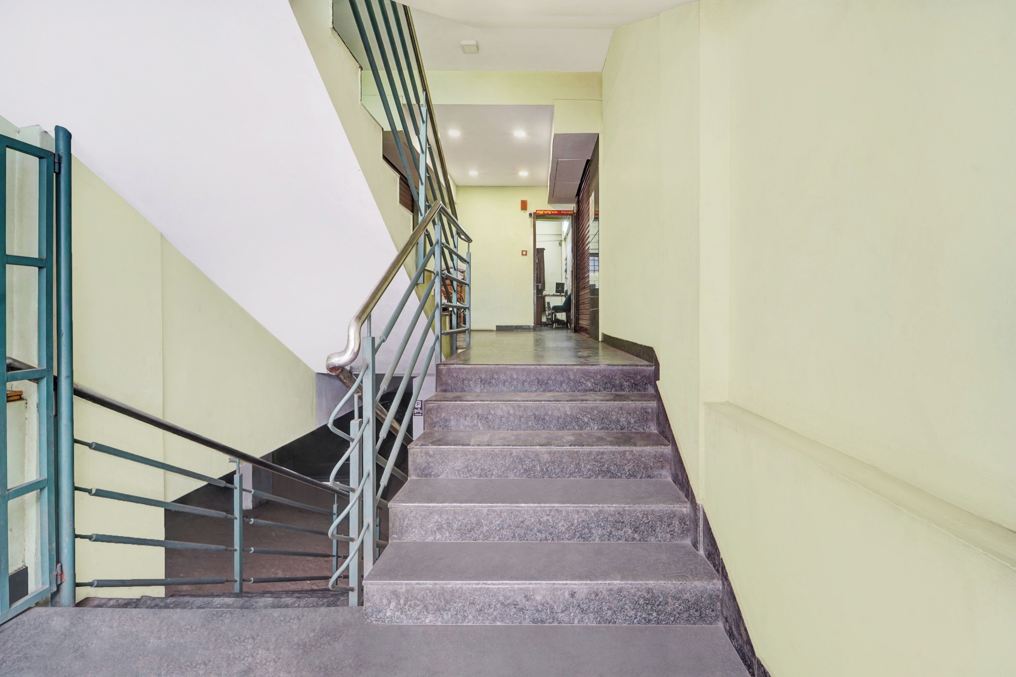 A staircase with metal railings leading to a landing.