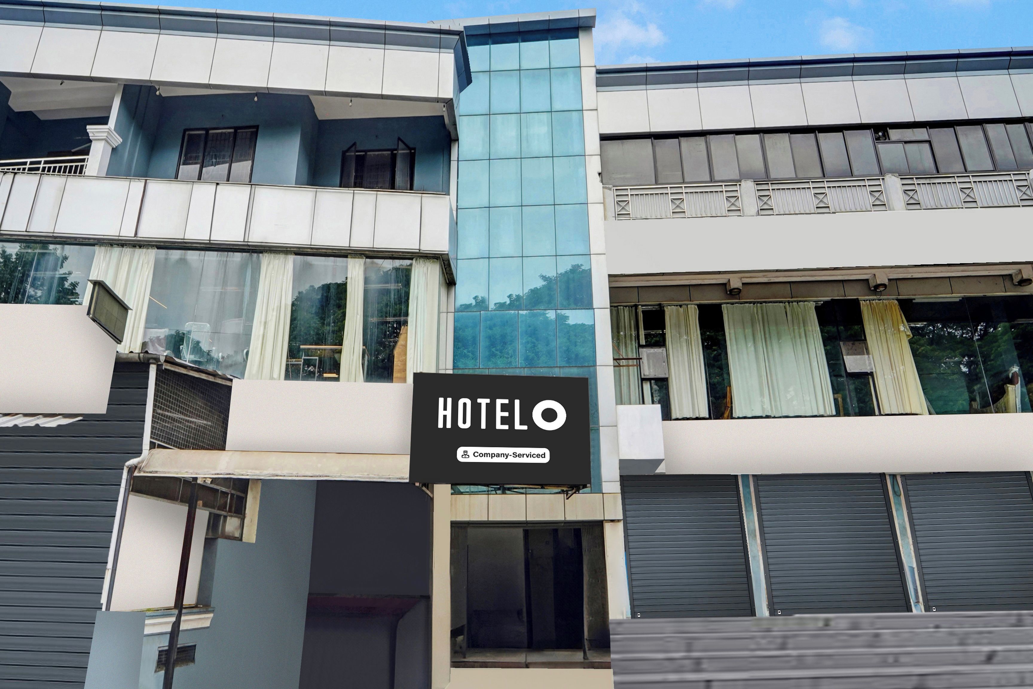 A hotel building with a sign indicating it is company-serviced.
