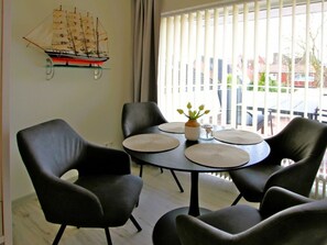 A dining area with a round table, black chairs, and a ship model on the wall. - 19 Grosse Strasse, Holiday Apartment 1 (Wyk auf Foehr)