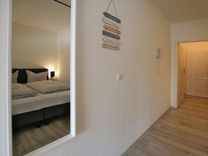 Ein Hotelzimmer mit Bett, Nachttisch und einer an der Wand befestigten Beschilderung mit Pfeilen.