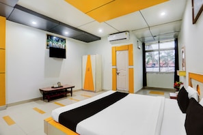 Ein Hotelzimmer mit Bett, Schreibtisch, Kleiderschrank, Klimaanlage und einem Fenster mit Blick.