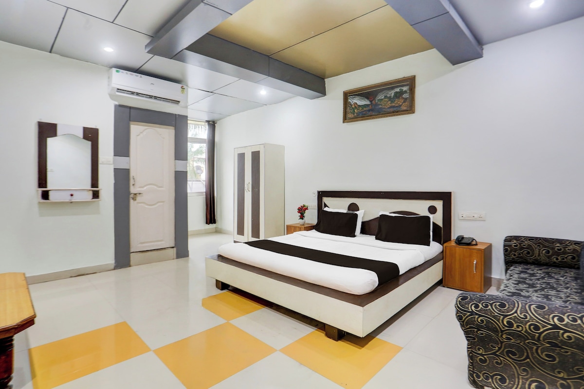 Una habitación de hotel con cama, mesita de noche y sofá.