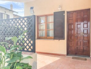 A house with a wooden door, a window with shutters, and a lattice fence. - La Casa del Nespolo - Two-Story Townhouse in Torrita di Siena (Torrita di Siena)