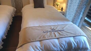 A hotel room with a bed, a nightstand, a lamp, and a window with curtains.