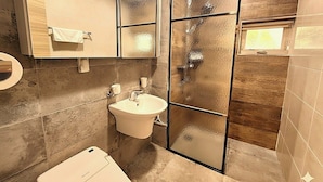 Ein Badezimmer mit Toilette, Waschbecken und Spiegel.