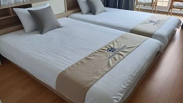 A hotel room with two beds, a wooden headboard, and a view of the outdoors.