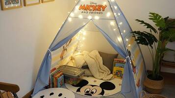 Una tienda de juegos temática de Mickey Mouse con un saco de dormir y libros.