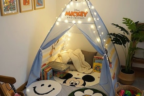 Una tienda de juegos temática de Mickey Mouse con un saco de dormir y libros.