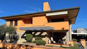 Ein modernes Haus mit einem einzigartigen architektonischen Design, das durch einen markanten Überhang und ein Steinfundament gekennzeichnet ist.