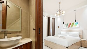 Quarto moderno com uma cama grande, uma mesinha de cabeceira e um criado-mudo.