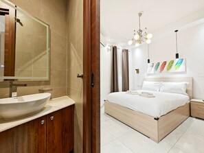 A modern bedroom with a large bed, a bedside table, and a nightstand.