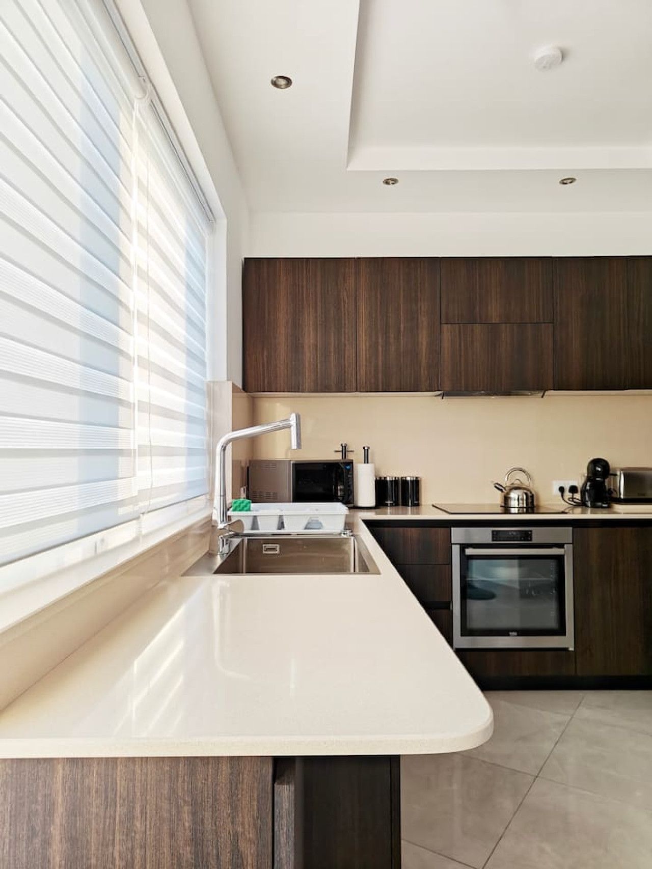 A modern kitchen with a built-in oven, a microwave, and a sink.