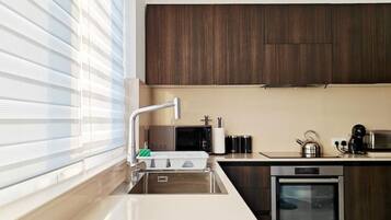 A modern kitchen with a built-in oven, a microwave, and a sink.