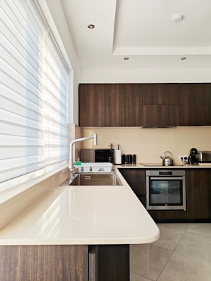 A modern kitchen with a built-in oven, a microwave, and a sink.