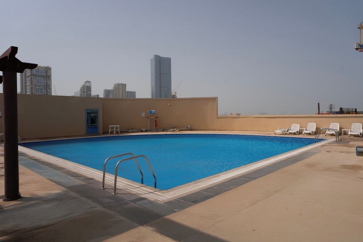 Une piscine avec la silhouette de la ville en arrière-plan.