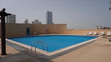 Une piscine avec la silhouette de la ville en arrière-plan.