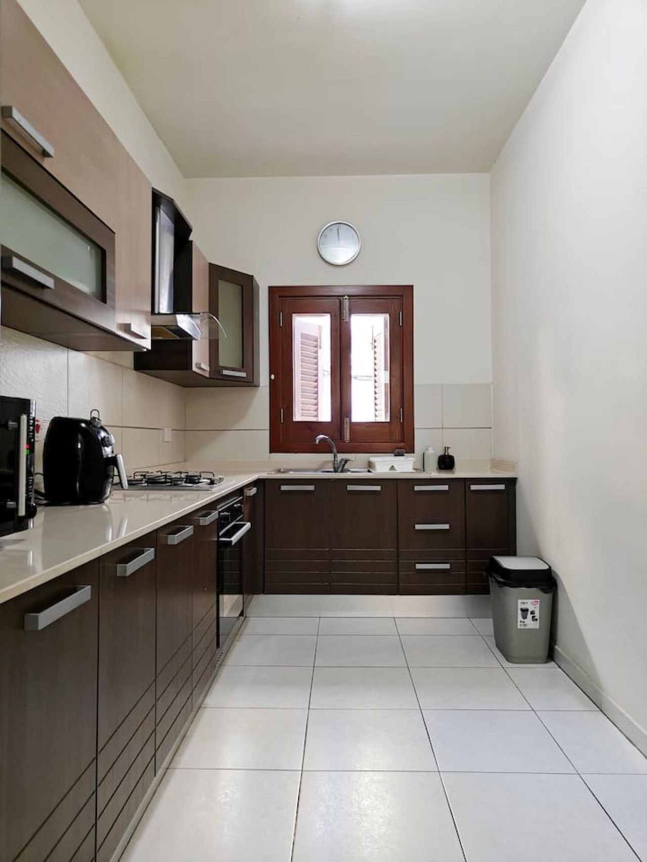 A modern kitchen with a built-in oven, microwave, and a double sink.