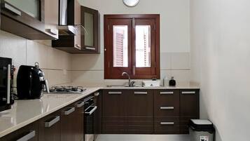 A modern kitchen with a built-in oven, microwave, and a double sink.