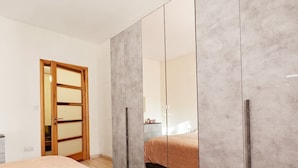 A bedroom with a bed, a wardrobe, and a mirror. - Ivy 2 bedroom apartment (Swieqi)
