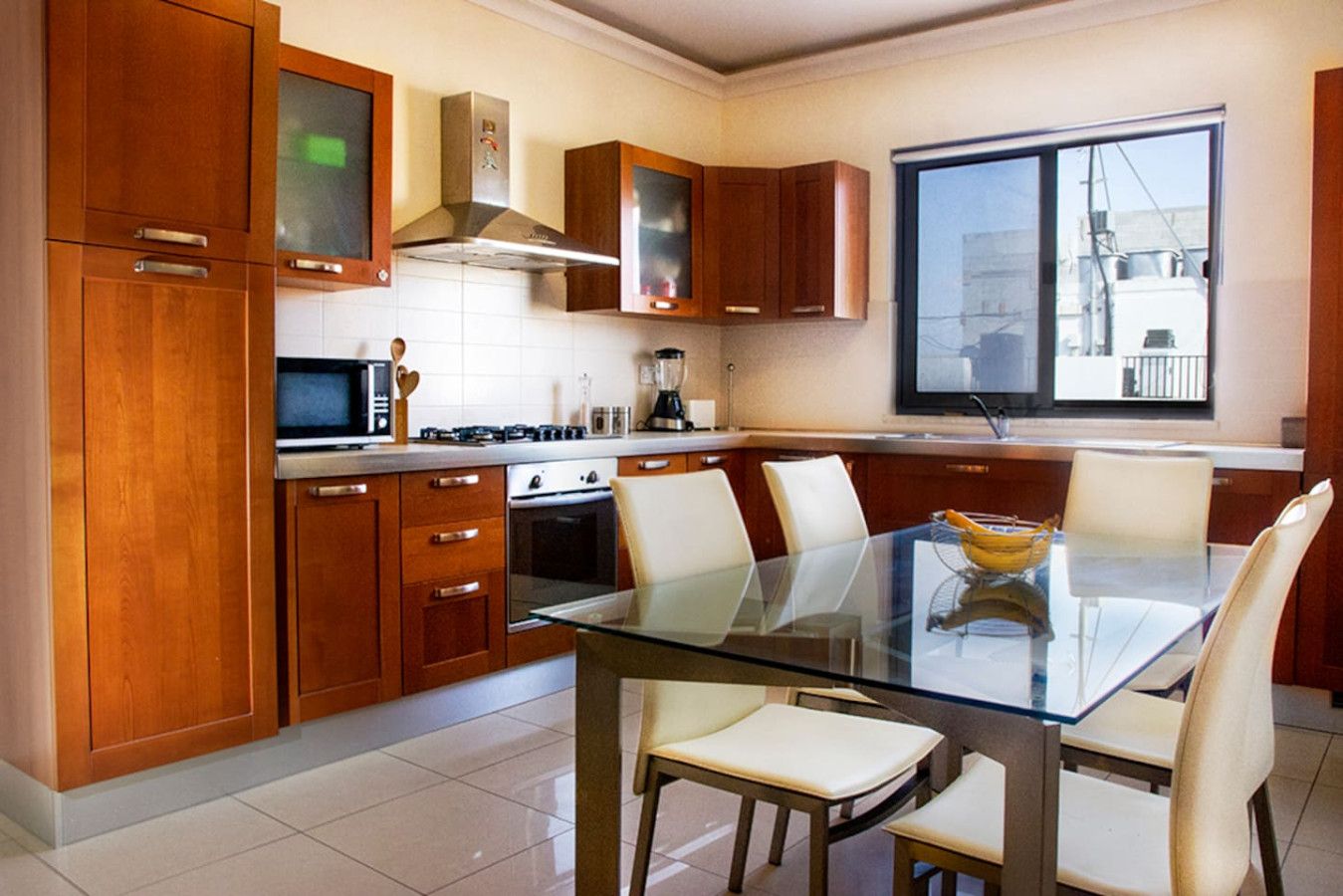 A modern kitchen with wooden cabinets, a glass dining table, and a large window.
