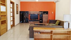 A living room with a television, sofa, and coffee table. - Ivy 2 bedroom apartment (Swieqi)