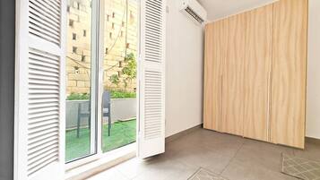 A room with a sliding glass door, a wooden wardrobe, and a tiled floor.