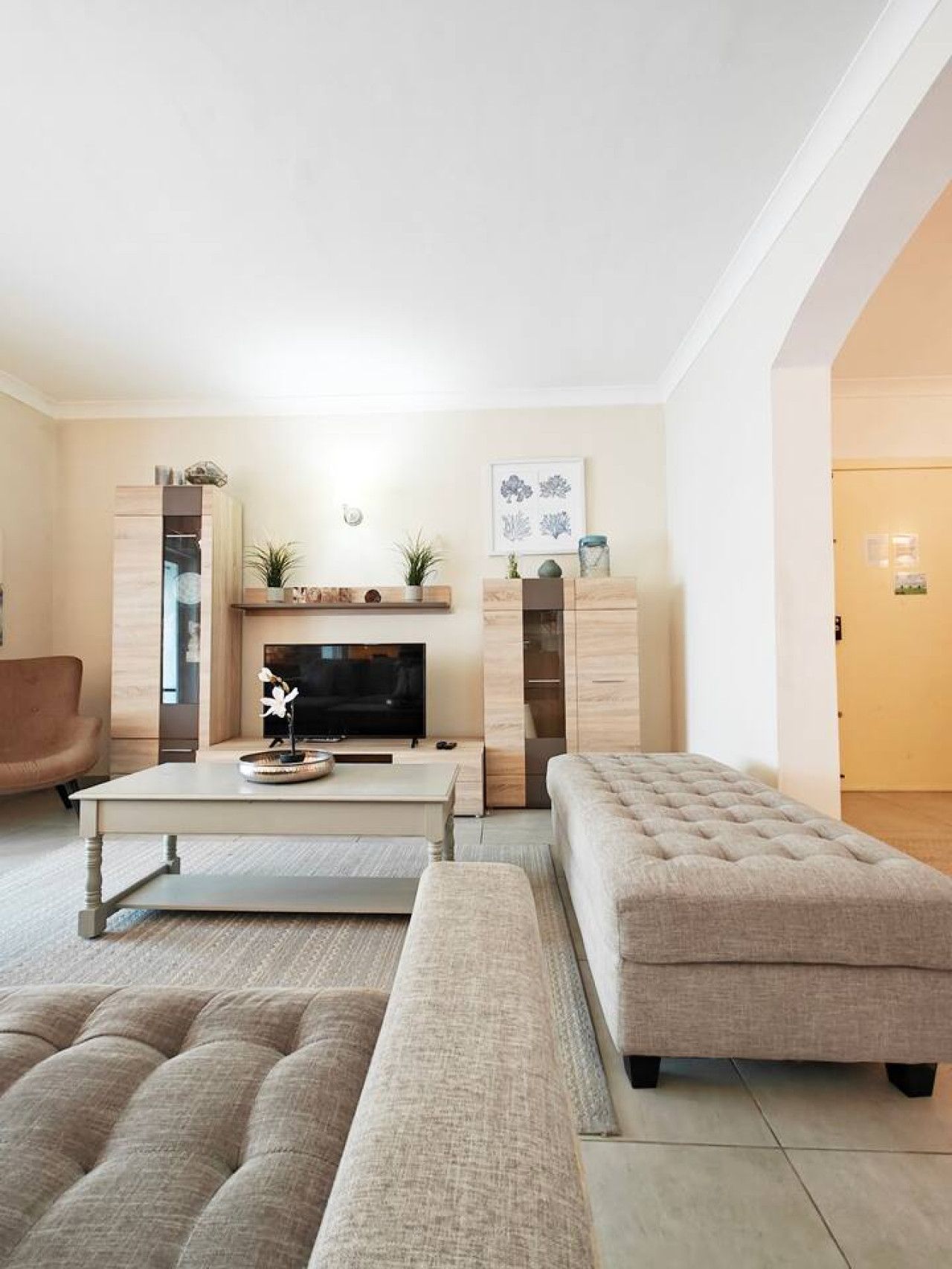 A modern living room with a fireplace, a flat-screen TV, and a comfortable sofa.