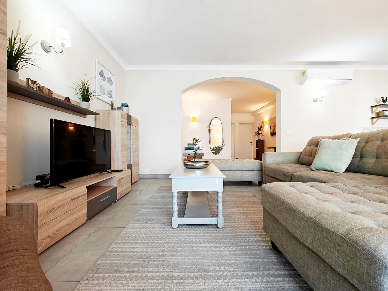 Ein modernes Wohnzimmer mit Flachbildfernseher, Couchtisch und Sofa.