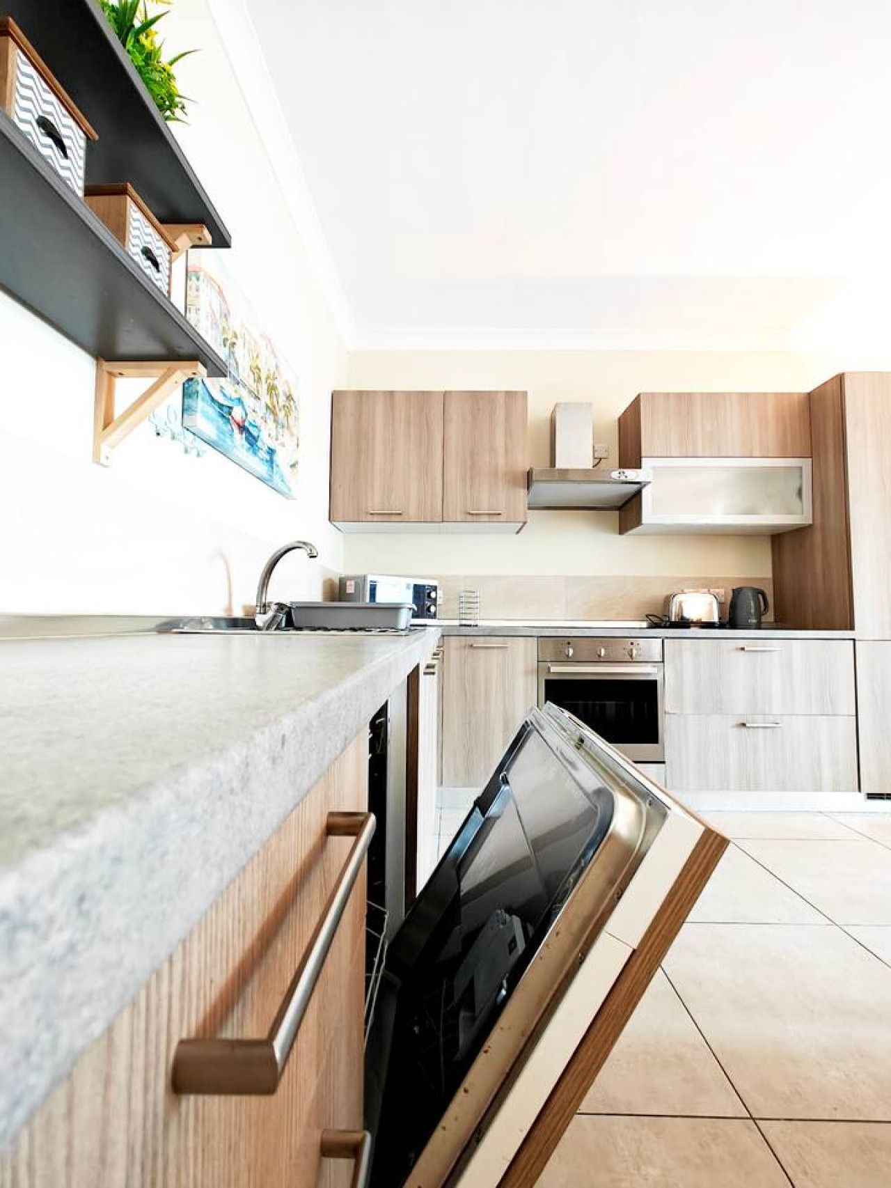 A modern kitchen with wooden cabinets, a built-in oven, and a dishwasher.