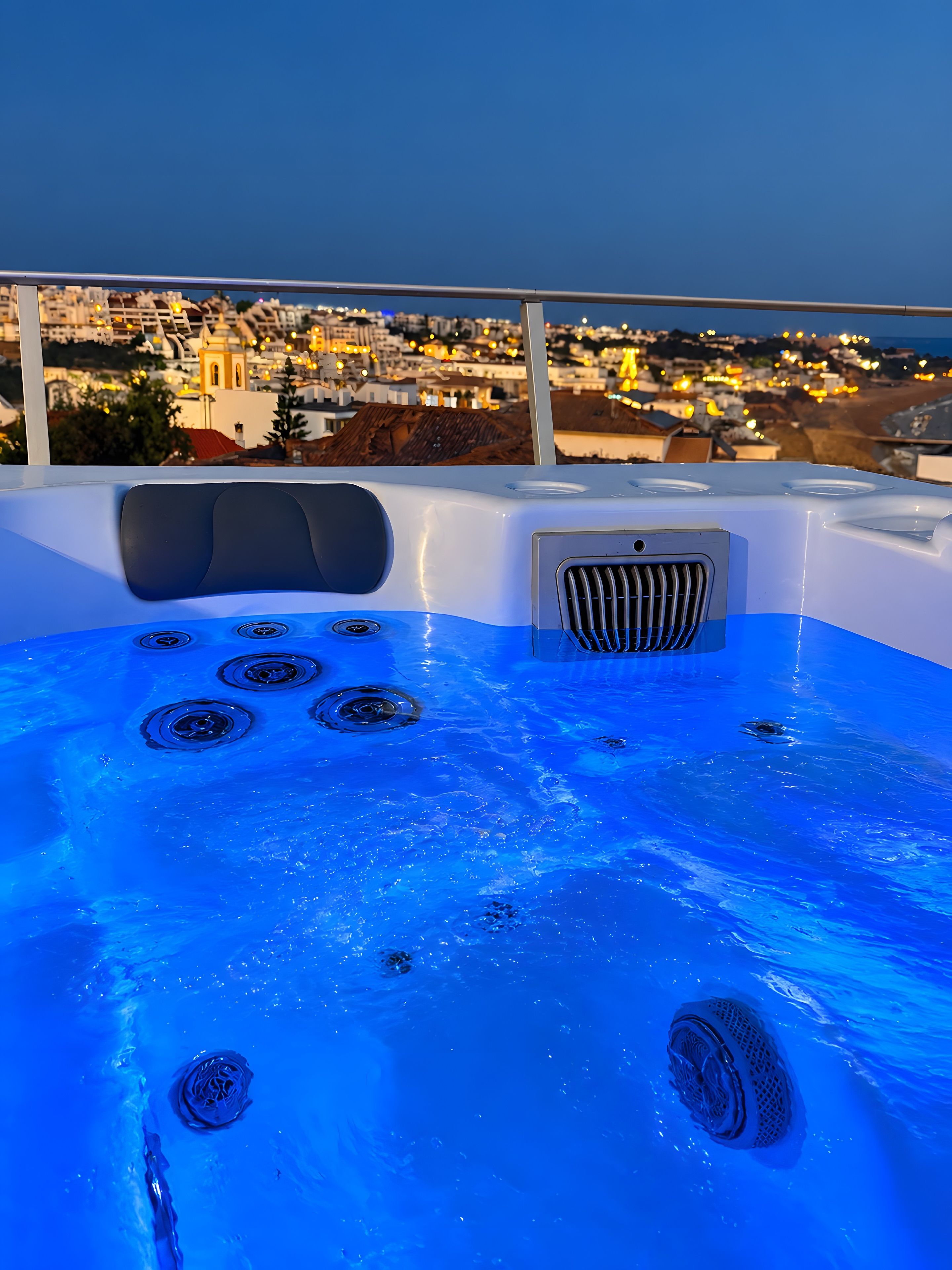 A hot tub with a cityscape view, a control panel, and a seating area.