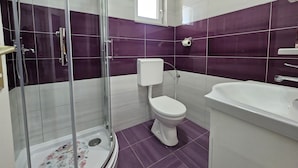 Ein Badezimmer mit einer Duschkabine, Toilette und Waschbecken.