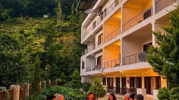 A multi-story building with outdoor seating areas and a fire pit.