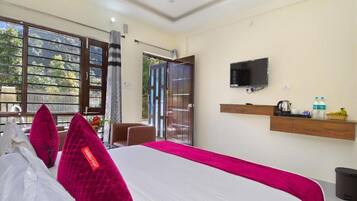 A hotel room with a bed, a television, a window with a view, and a door leading outside.
