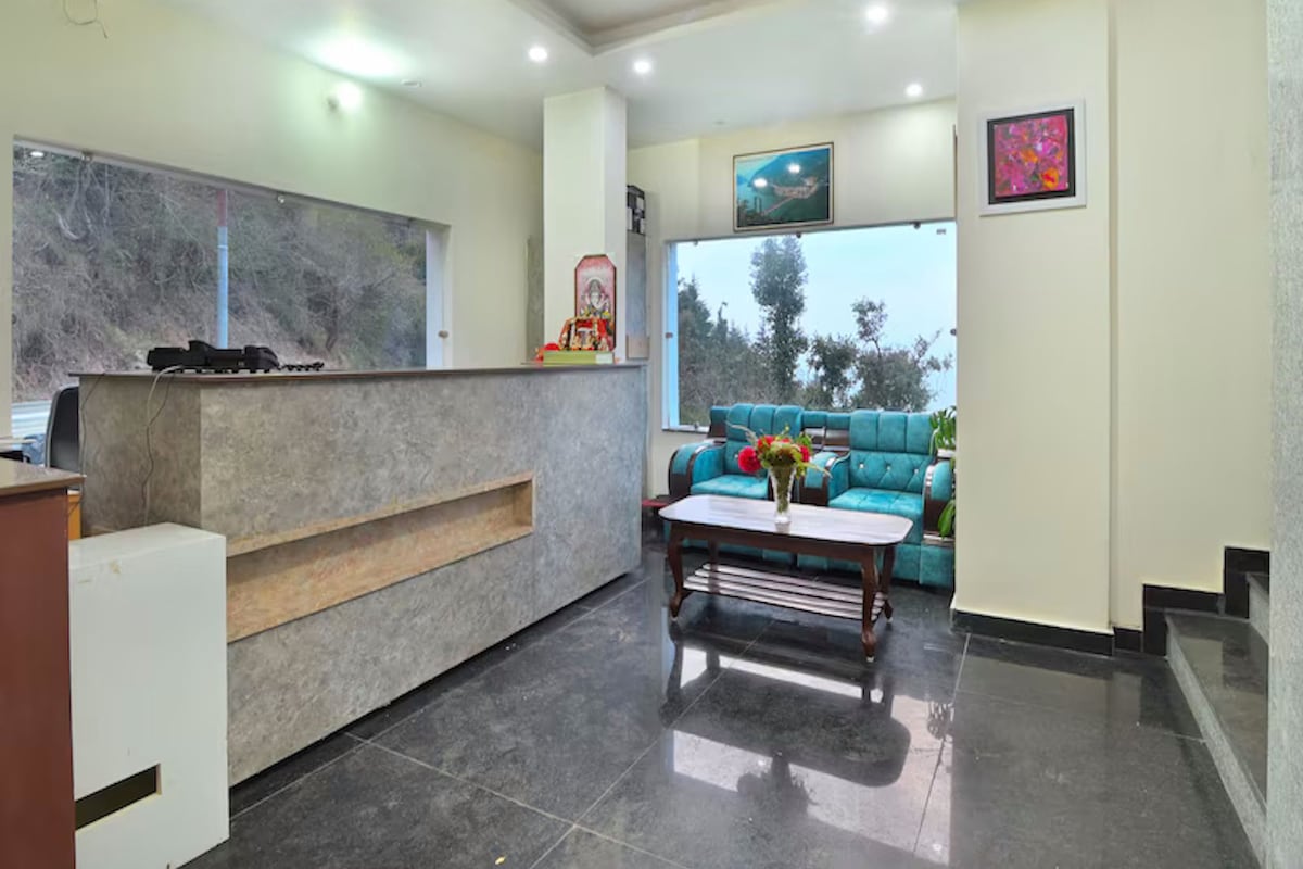 A reception area with a marble counter, a blue sofa, and a coffee table with flowers.