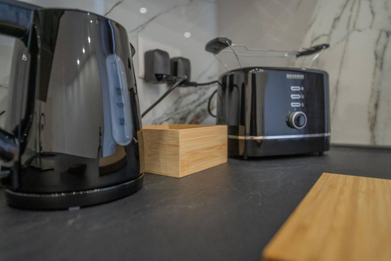 Een keukentafel met een koffiezetapparaat en een broodrooster.