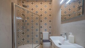Ein Badezimmer mit Dusche, Toilette und Waschbecken.