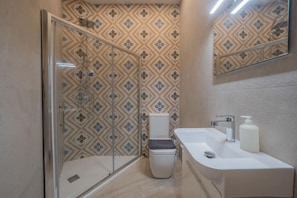 Un baño con ducha, inodoro y lavamanos.