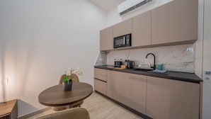 Eine moderne Küche mit eingebauter Mikrowelle, Spüle und Kaffeemaschine.