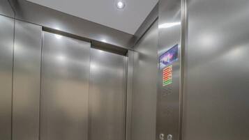 Un ascensore moderno con pareti metalliche e un pannello di controllo con pulsanti.