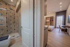 Un baño moderno con ducha, inodoro y azulejos estampados.