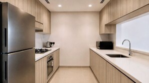 A modern kitchen with stainless steel appliances, a microwave, and a sink. - Vanilla Homes Premium 1BR Yas Island (Abu Dhabi)