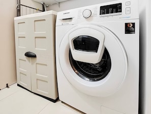 A white Samsung digital inverter washing machine with a control panel and a door with a handle. - Good Times apartment (Sliema)